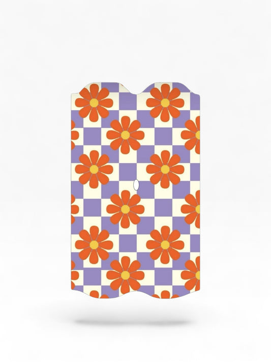 Cloud Skinz waterproof Vuse Alto decal featuring a retro purple and white checkerboard pattern with orange daisies.